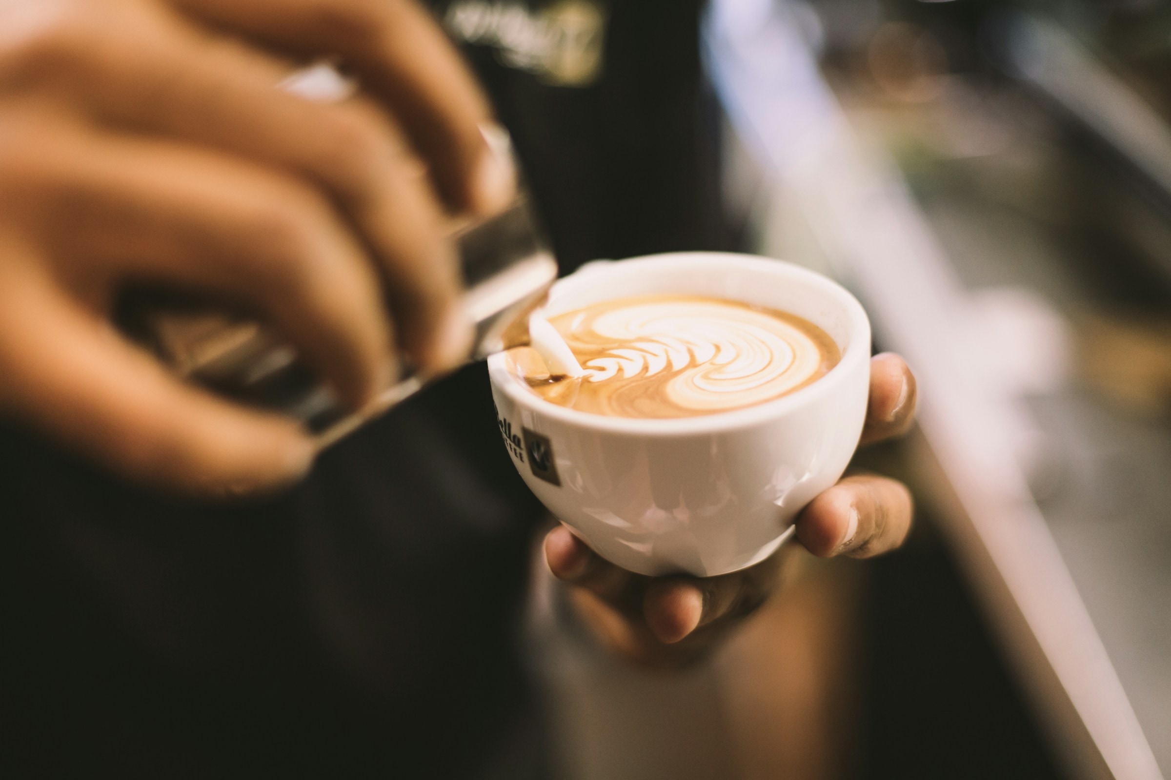 Flat white with rosetta latte art in a ceramic cup
