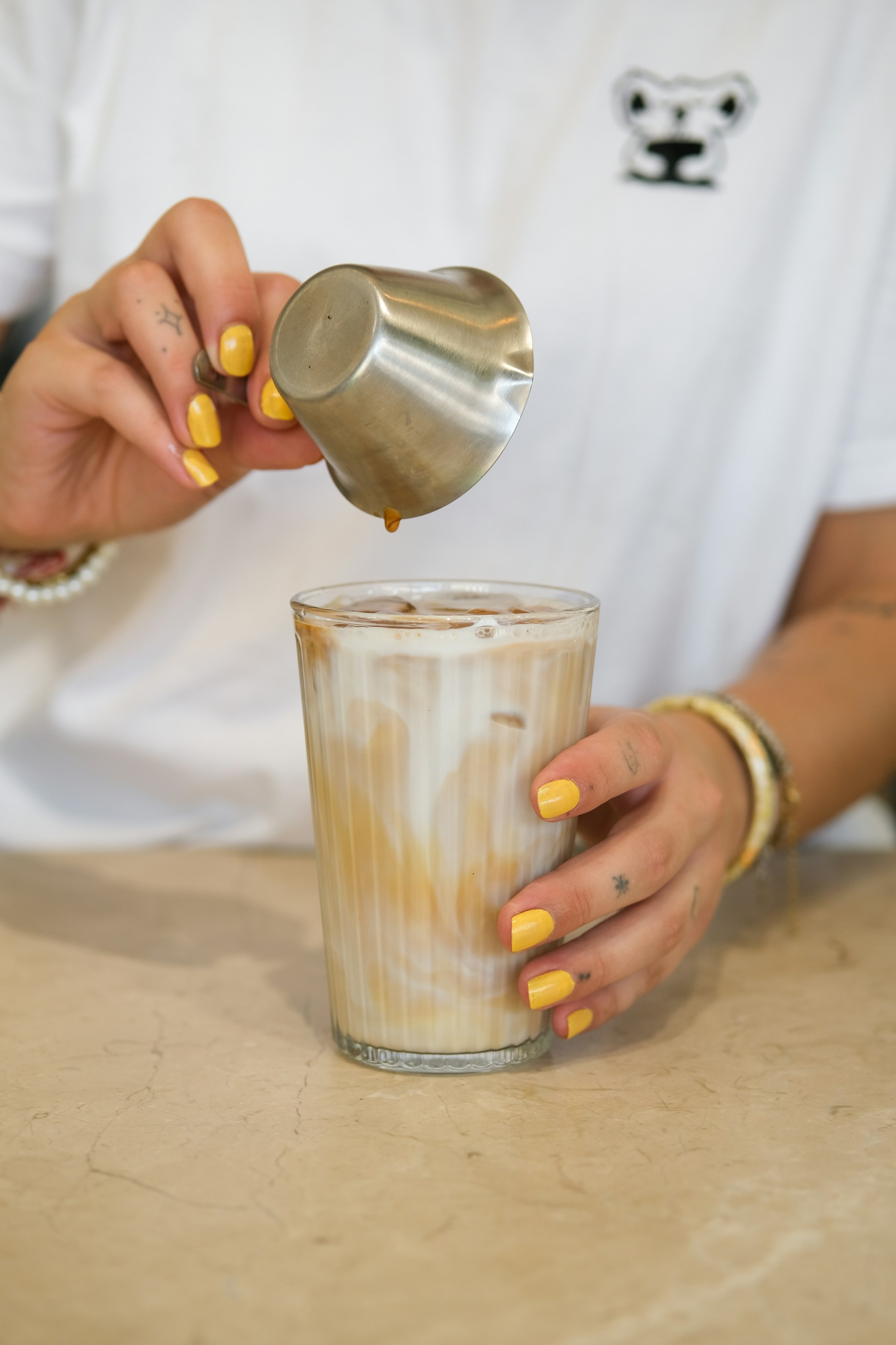 Espresso poured over milk and ice — iced Spanish latte